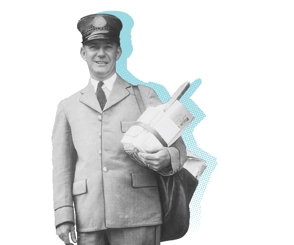 A mail carrier holds a bundle of mail under the same arm as their mail bag.