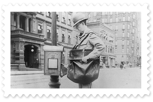 A black-and-white photograph of a postal worker emptying a collection box mounted to a streetlamp.