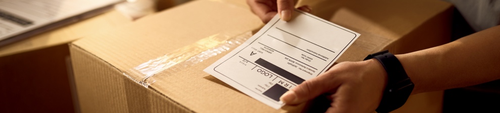 Person preparing a shipping label for a Priority Mail box.