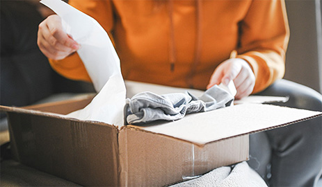 Customer taking items out of an open shipping box.