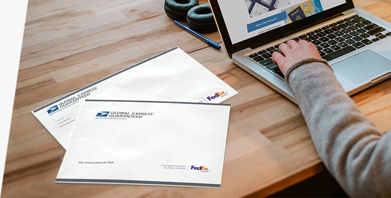 Two GXG® envelopes on a desk being prepared for sending.