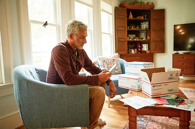 A person sitting on a chair with open shipping boxes in front of them.