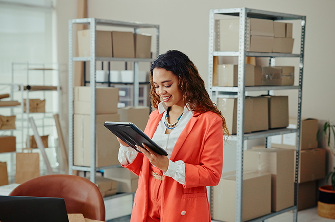 A person standing in front of a shelf of Ground Advantage packages ready to ship.