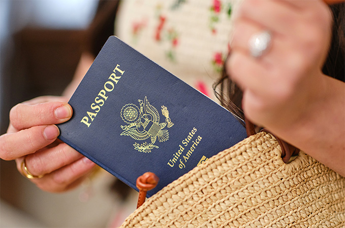 A person pulling a passport from a purse.