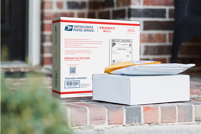 Priority Mail boxes on a house porch awaiting pickup.