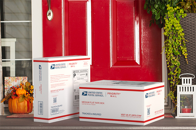 Priority Mail boxes on a house porch awaiting pickup.