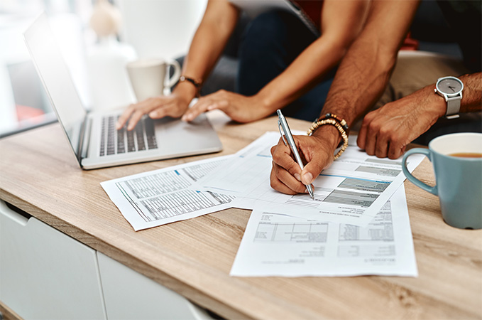 An IRS form 1040 on desk with people in the background working on paperwork.