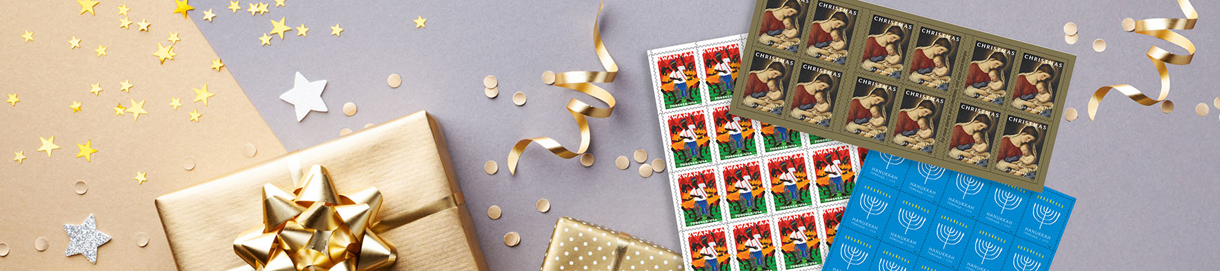 Holiday stamps on a table with a packaged gift, and holiday wrapping supplies.